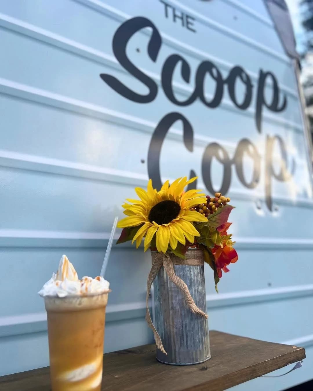 Caramel milkshake topped with whipped cream and caramel drizzle, set in front of the Scoop Coop wordmark