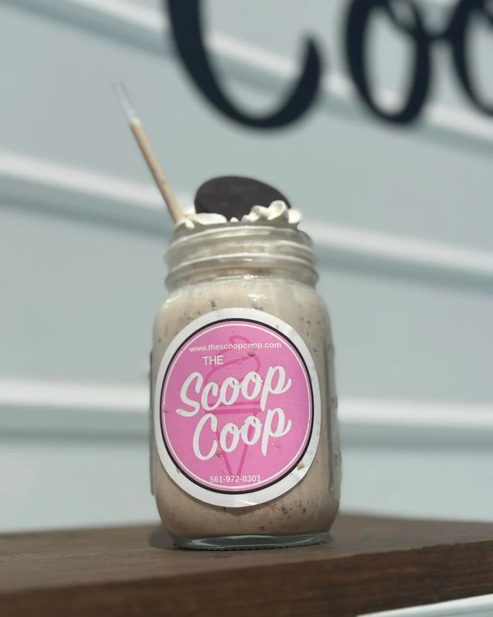 Cookies-and-cream mason-jar milkshake with the Scoop Coop label, whipped cream and an Oreo on top