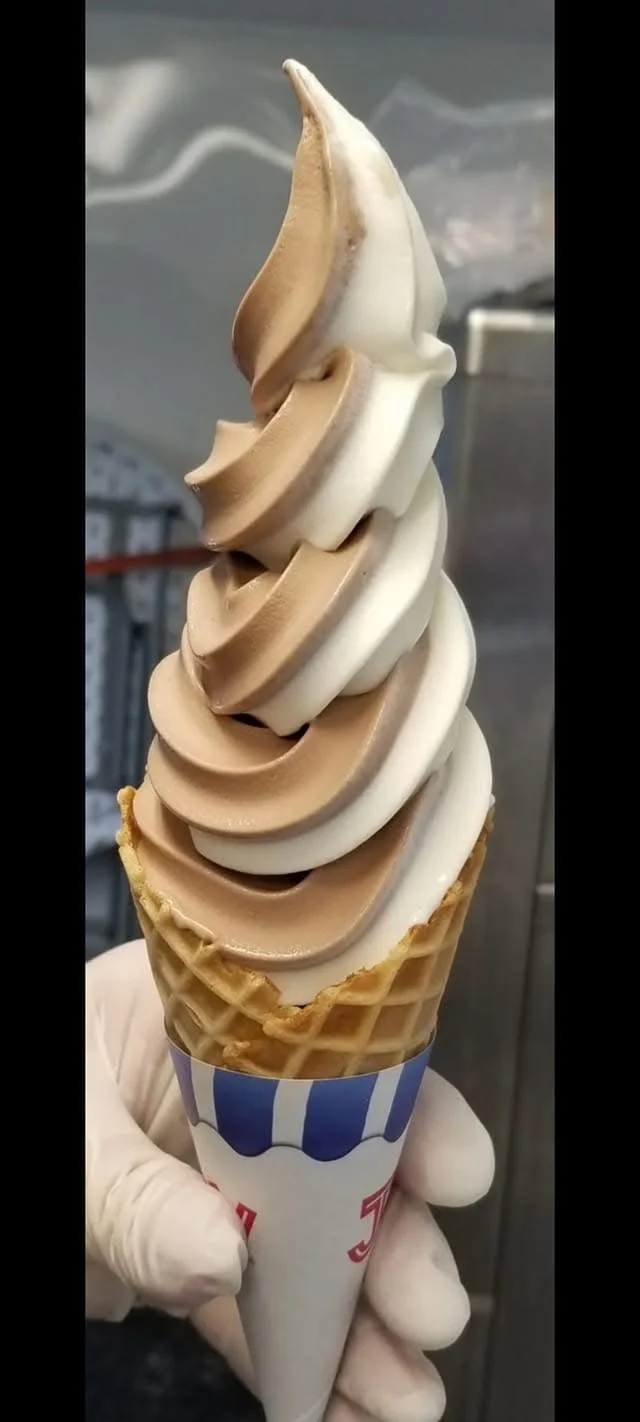 Hand-pulled chocolate-and-vanilla swirl soft-serve in a striped waffle cone